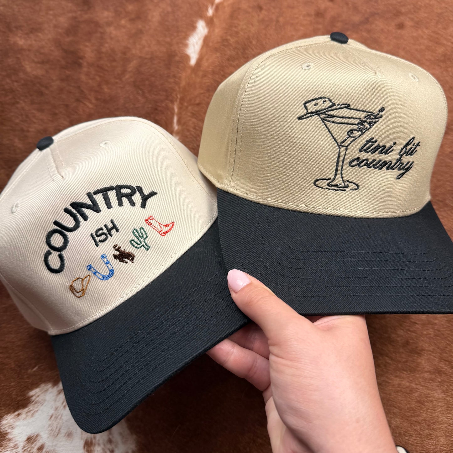 Embroidered western themed trucker hat in black and beige says "Tini bit country" with a martini glass. Western fashion. Cowgirl outfits.