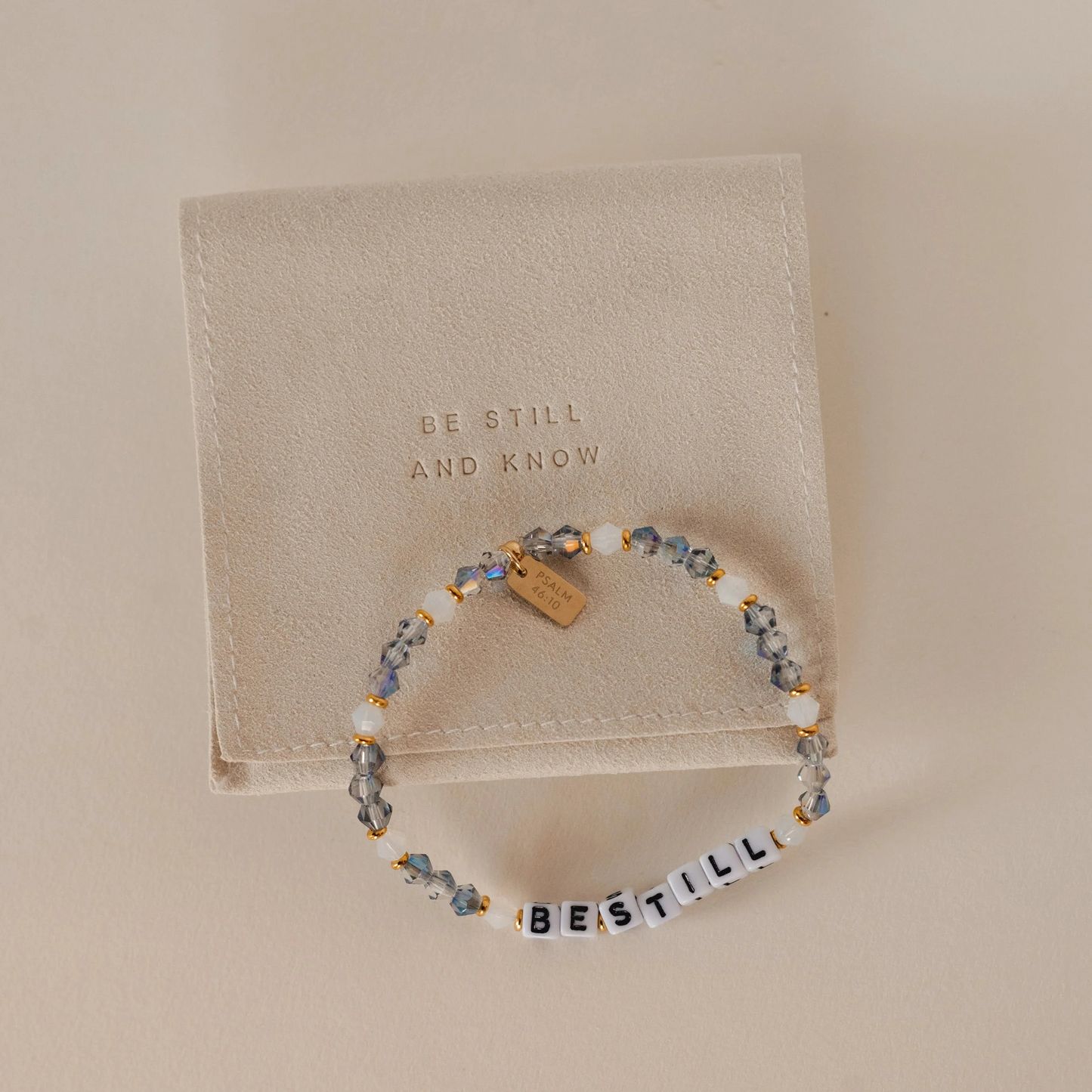 Beaded bracelet with 'Be Still and Know' message on a beige background