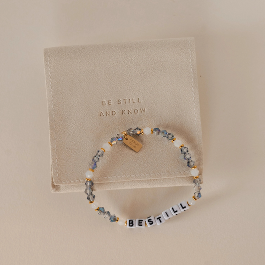 Beaded bracelet with 'Be Still and Know' message on a beige background