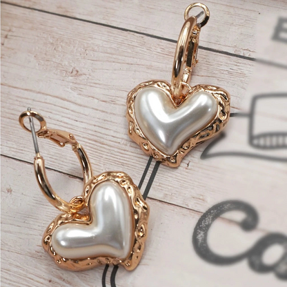 Heart-shaped earrings with gold and pearl details. Women's feminine and classy jewelry.