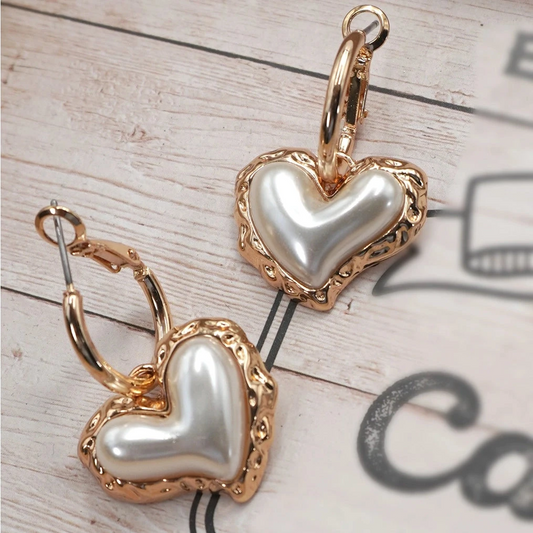 Heart-shaped earrings with gold and pearl details. Women's feminine and classy jewelry.