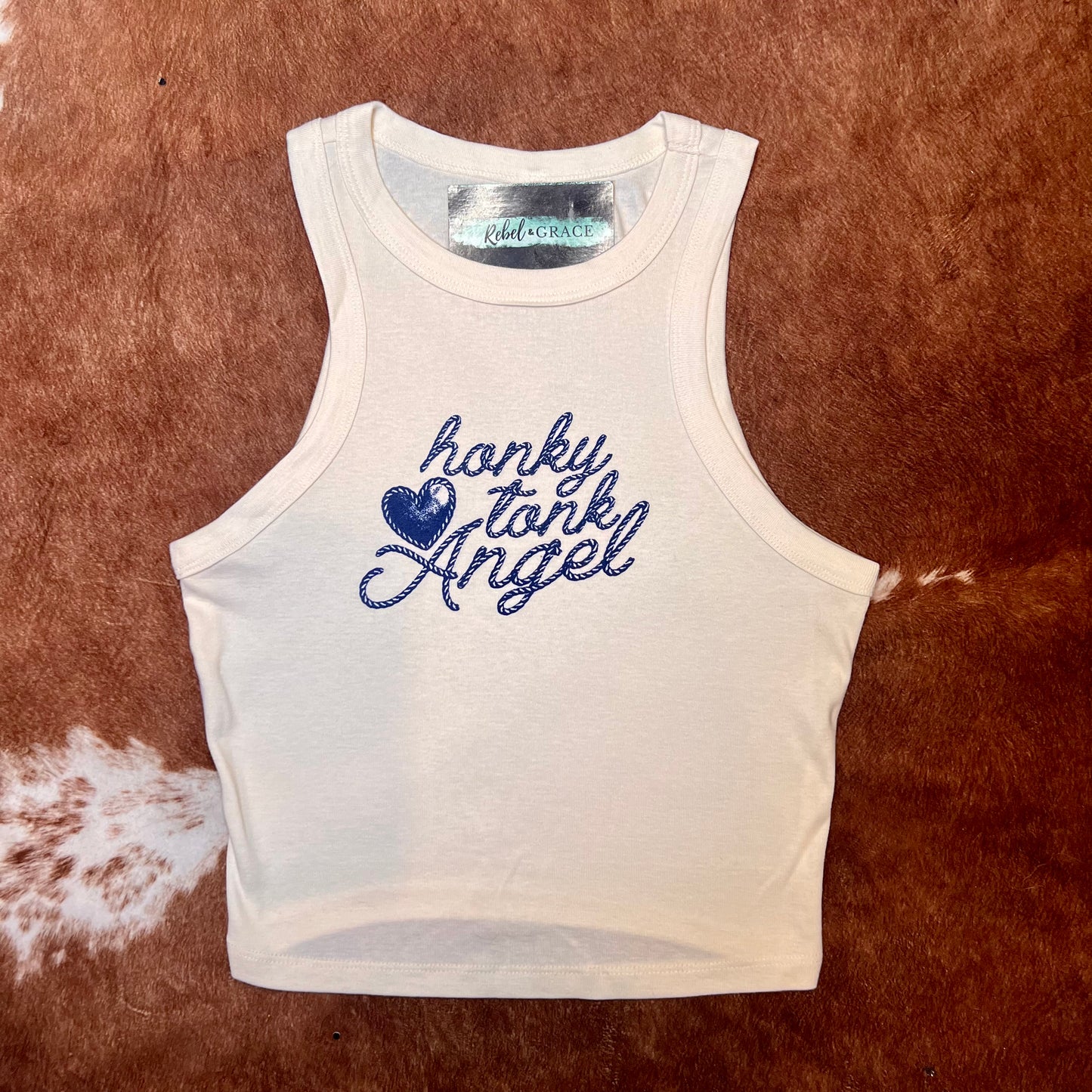 Off-white racerback style cropped women's western tank top with words Honky Tonk Angel printed on front in lasso style font 