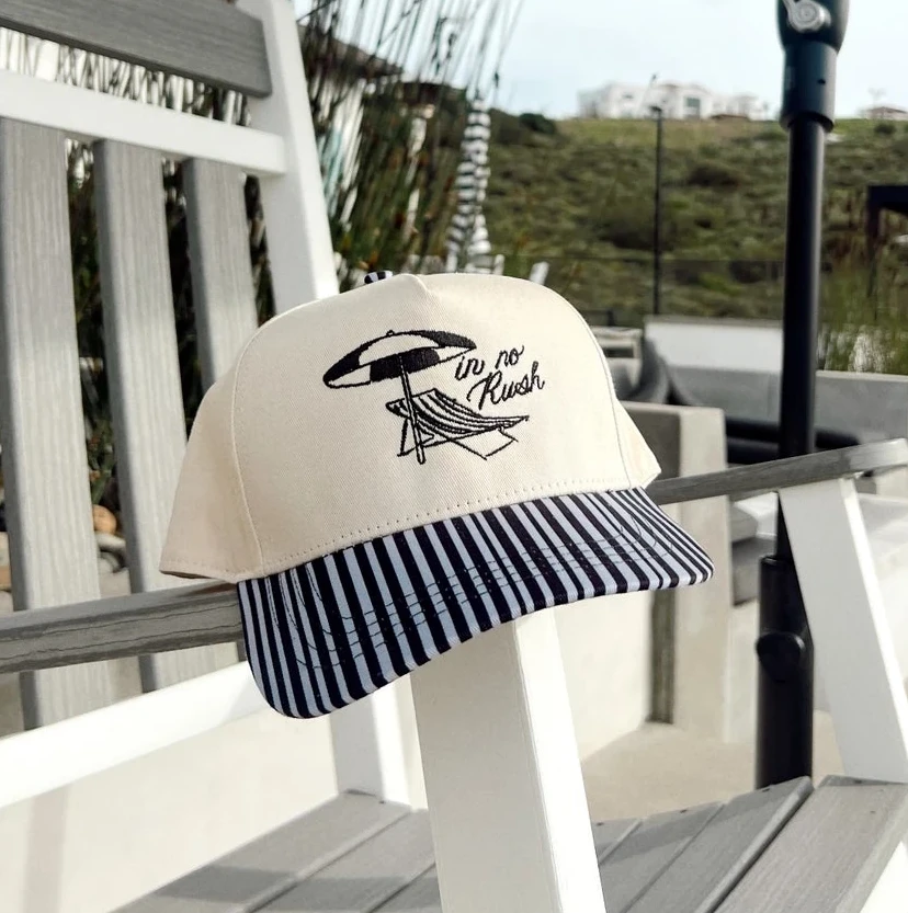 Women's summer beach trucker hat. in no rush embroidered with a lounge chair and umbrella detail. 