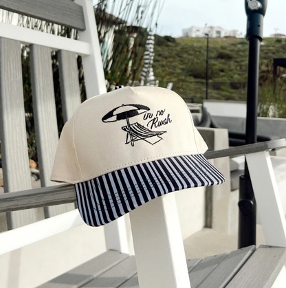 Women's summer beach trucker hat. in no rush embroidered with a lounge chair and umbrella detail. 