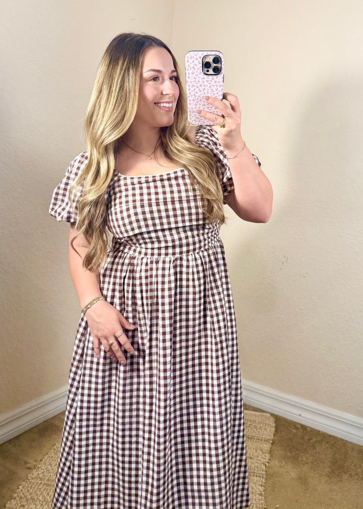 Women's brown gingham midi dress styled with cowboy boots for a cute fall or Thanksgiving outfit.