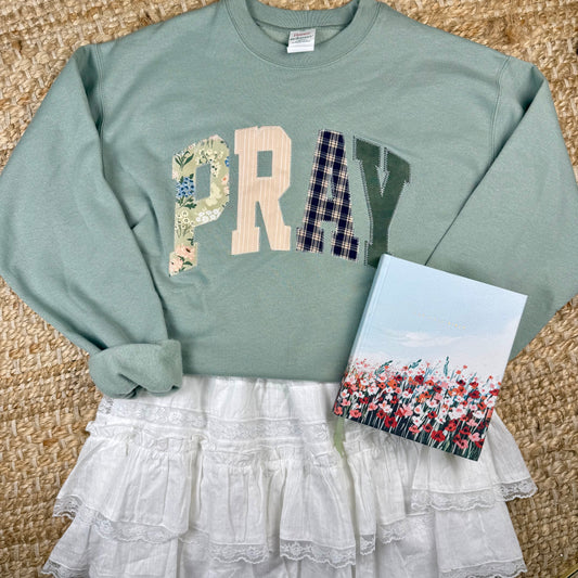 sage green crewneck with pray stiched on it in a patchwork design. christian women's outfits, church outfits, christian women fall outfits