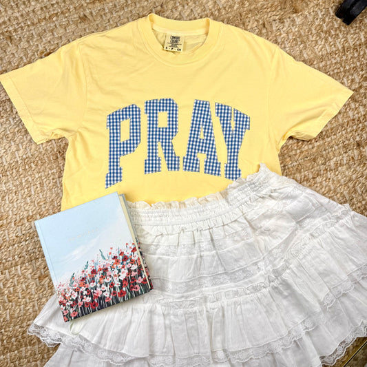 yellow t-shirt with blue gingham lettering stitched on spelling out pray. women's christian based boutique. women's church outfits. women's trendy church outfits.