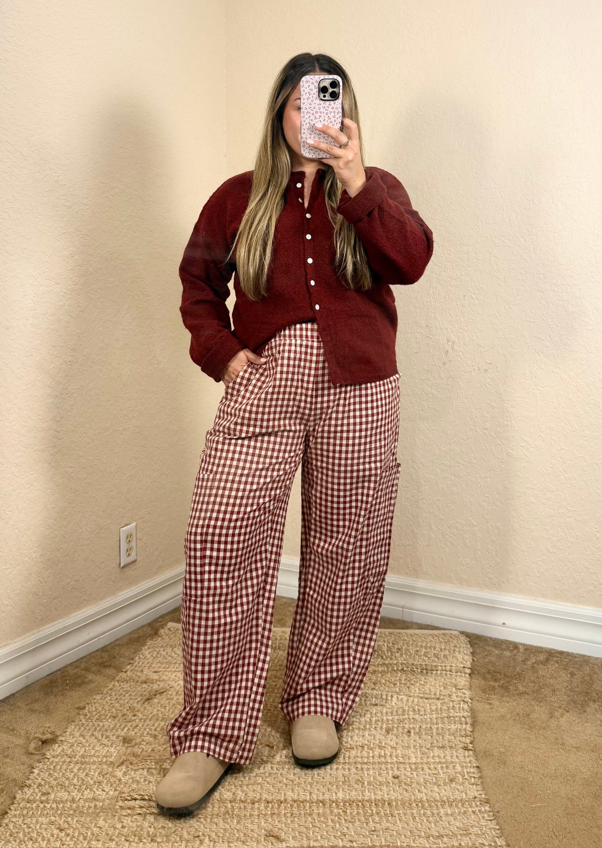Woman wearing cherry red gingham pants with a burgundy cardigan for a fall outfit