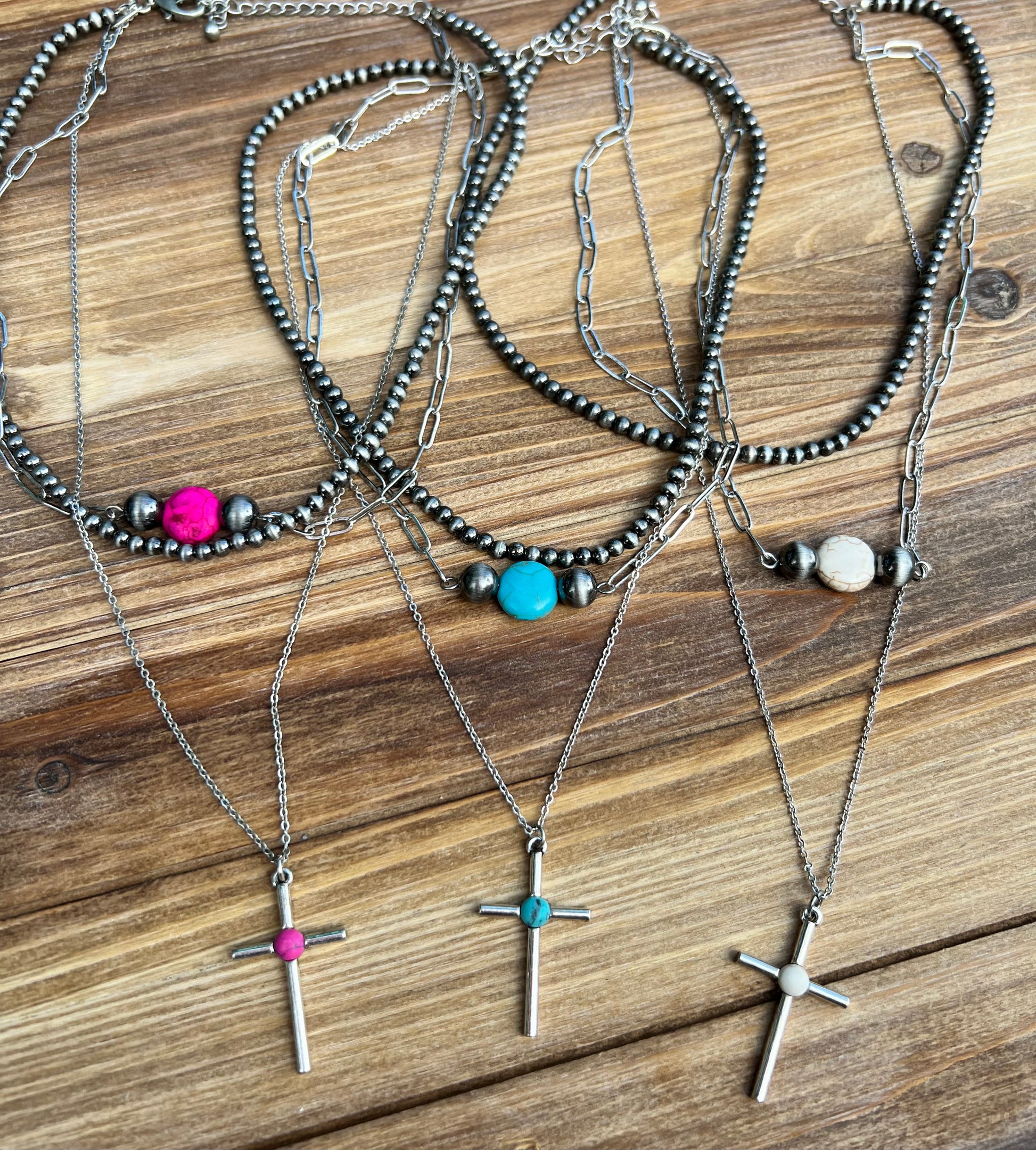 Set of 3 individual necklaces in faux turquoise, hot pink, and white with silver chain and faux navajo pearls. Each necklace is individually stacked to have three layers but is still one necklace that has lobster claw clasp and 2 inch adjustable chain